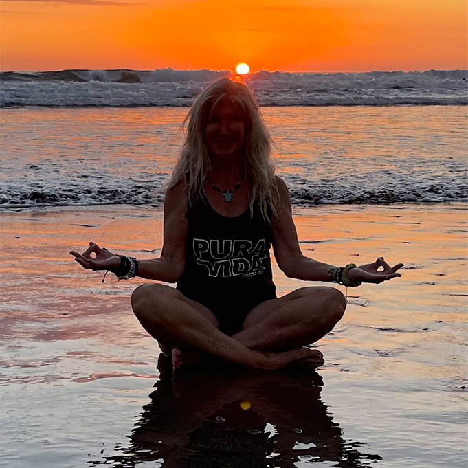 Dr. Trish Sanders meditating on the beach